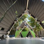 Morris Ave Park view inside the main play structure for ages 2-5. Looking from one covered pod to another across a cargo net bridge.