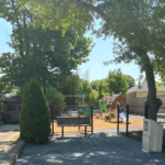 Morris Ave Park entrance features bench seating and little free library