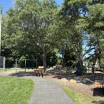 Mt Pleasant Little League Park entrance to the playground with ample bench seating along a paved walkway