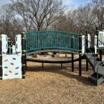 Paterson Park play structure for ages 5-12 features a classic rock climber, arched bridge, and accessible transfer stair