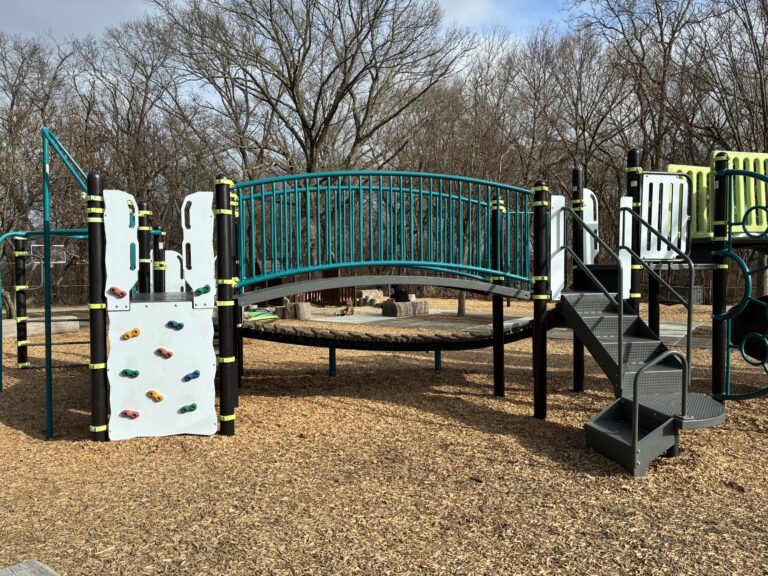 Paterson Park play structure for ages 5-12 features a classic rock climber, arched bridge, and accessible transfer stair