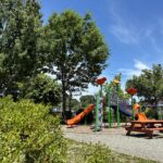 Peace & Plenty Park looking northeast at the playground and picnic tables from in the bushes