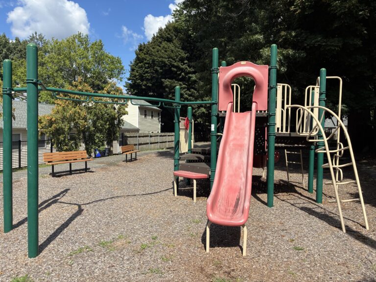 Pleasant St Park features park benches and play equipment for ages 2-12