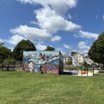 Richardson Park grassy area behind Al Carrington waterpark with mural on building