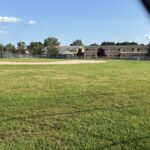 Richardson Park baseball field closed for renovations looking at sprinklers through the outfield fence
