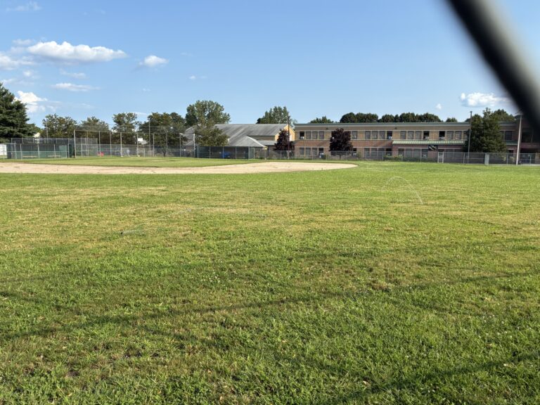Richardson Park baseball field closed for renovations looking at sprinklers through the outfield fence
