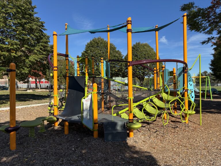 Richardson Park unique play structure for ages 5-12 features an obstacle course layout with various nets, ropes, belts, and traditional decks