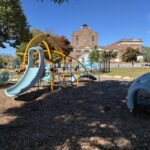 Richardson Park play area for ages 2-5 with ample shade and iconic Providence architecture in the background- Roger Williams Middle School