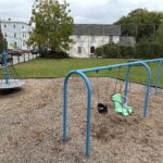 Ridge St Park playground swings for ages 2-12 and carousel spinner, north lawn with picnic table