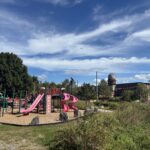 Riverside Park playground for ages 2-12 against the Olneyville skyline with one Atlantic Mills tower visible