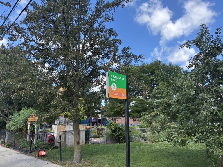 Sessions Street Park entrance sign in front of the garden