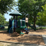 Sessions Street Park playground for ages 5-12 with fresh engineered wood fiber mulch safety surfacing installed by Parks crew in Summer 2026