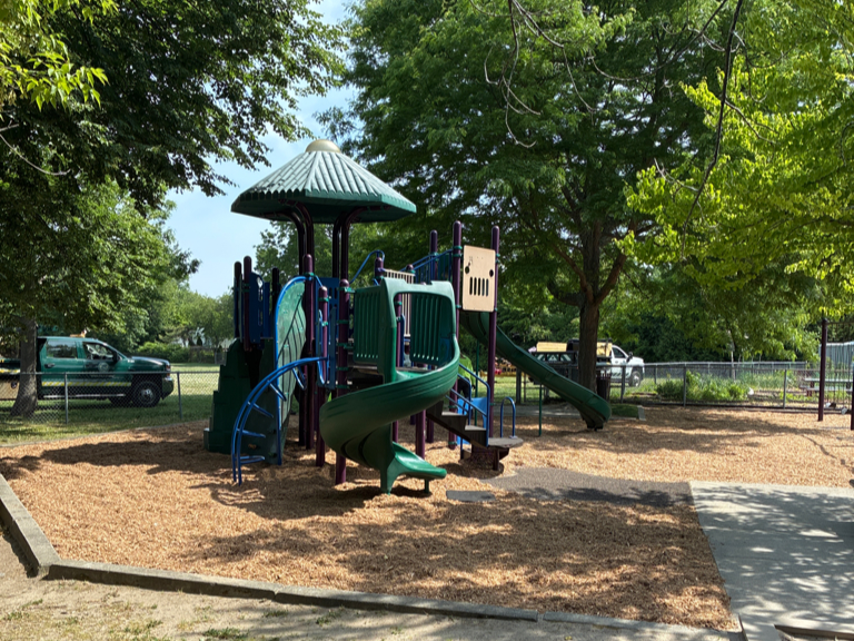 Sessions Street Park playground for ages 5-12 with fresh engineered wood fiber mulch safety surfacing installed by Parks crew in Summer 2026